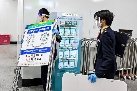 광저우 지하철역 코로나19 코드 포스터 제거하는 직원