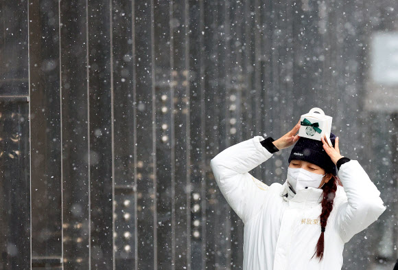 본격적인 겨울을 알리는 눈이 내린 13일 오후 서울 서대문구 이화여자대학교에서 한 학생이 기념사진을 위해 포즈를 취하고 있다. 2022.12.13  연합뉴스