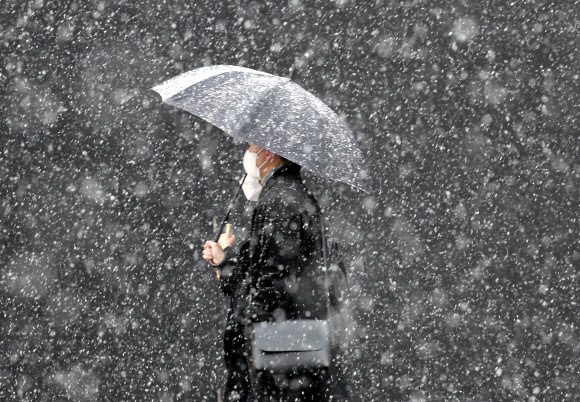 13일 오후 시민들이 눈 내리는 광화문 광장을 지나가고 있다. 2022.12.13  연합뉴스