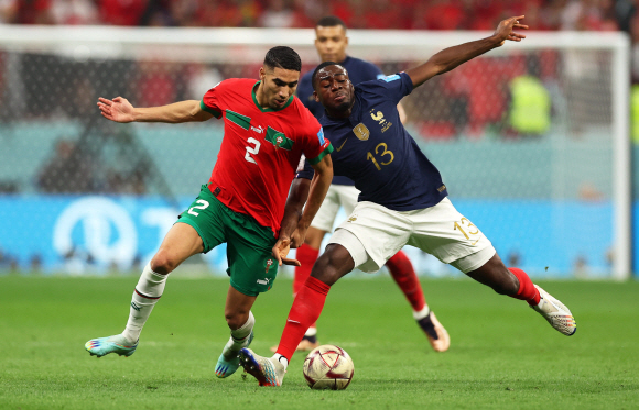모로코의 아흐라프 하키미(L)가 2022년 12월 14일 카타르 알코르의 알베이트 스타디움에서 열린 프랑스와 모로코의 2022년 FIFA 월드컵 준결승전에서 프랑스의 유수프 포파나(R)를 상대로 경기에 나섰다.  EPA/Tolga Bozoglu