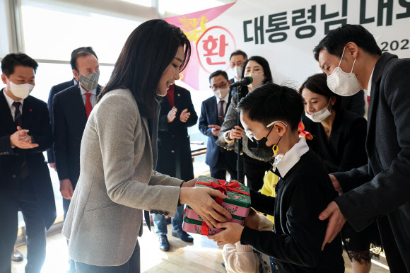 윤석열 대통령과 함께 17일 서울 서초동 아크로비스타 사저를 방문한 김건희 여사가 주민들에게 감사 인사를 전한 뒤 어린이들에게 선물을 전달하고 있다. 2022,12,17  대통령실 제공
