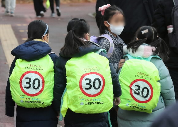 어린이보호구역(스쿨존)에서 음주 운전 차량에 치어 초등학생이 숨진 가운데 13일 서울 강남구 한 초등하교에서 학생들이 ‘스쿨존 입니다’ 메시지가 적힌 안전 가방을 메고 등교하고 있다. 2022.12.13 뉴스1