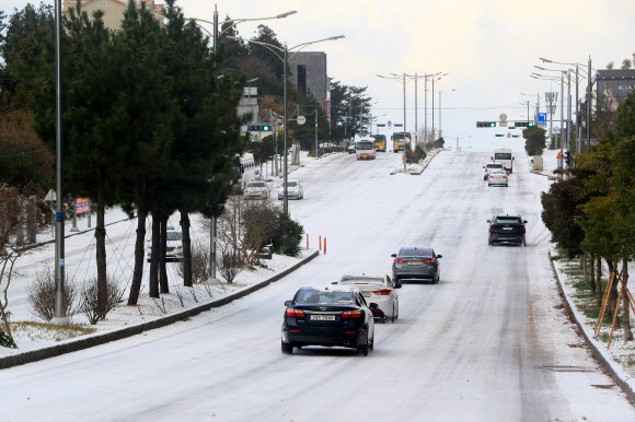 대설특보가 내려진 18일 오전 제주시의 도로가 밤새 내린 눈으로 빙판이 돼 있다. 2022.12.18  연합뉴스