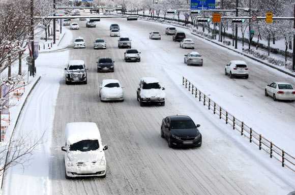 대설특보가 발령된 18일 광주 서구 한 도로에서 차량들이 눈길을 서행하고 있다. 2022.12.18  연합뉴스