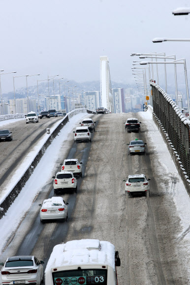 대설특보가 발령된 18일 광주 서구 한 도로에서 차량들이 눈길을 서행하고 있다. 2022.12.18  연합뉴스