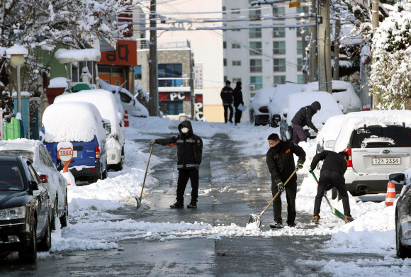 대설특보가 발령된 18일 광주 서부소방서 인근 거리에서 소방대원들이 길에 쌓인 눈을 치우고 있다. 2022.12.18  연합뉴스