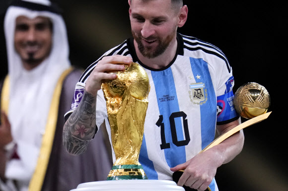 아르헨티나의 리오넬 메시가 19일 카타르 루사일의 스타디움에서 열린 아르헨티나와 프랑스의 월드컵 결승전 종료 후 트로피를 만지고 있다. 2022.12.19 AP연합뉴스