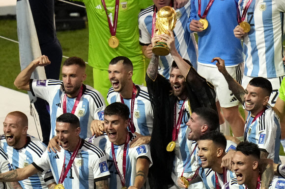 아르헨티나의 리오넬 메시가 19일 카타르 루사일 스타디움에서 열린 프랑스와의 월드컵 결승전에서 승리한 후 동료들과 함께 우승 트로피를 들고 축하하고 있다. 2022.12.20 AP연합뉴스