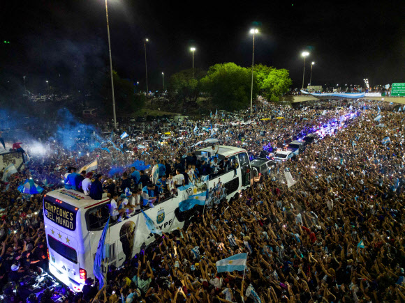 This aerial image taken on December 20, 2022 shows Argentina‘s players celebrating on board a bus with supporters after winning the Qatar 2022 World Cup tournament as they leave Ezeiza International Airport en route to the Argentine Football Association (AFA) training centre in Ezeiza, Buenos Aires province, Argentina. AFP 연합뉴스