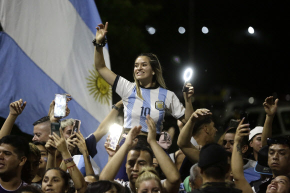 Argentina‘s supporters cheer Argentina’s players as they drive past on board a bus celebrating after winning the Qatar 2022 World Cup tournament as they leave Ezeiza International Airport en route to the Argentine Football Association (AFA) training centre in Ezeiza, Buenos Aires province, Argentina on December 20, 2022. AFP 연합뉴스
