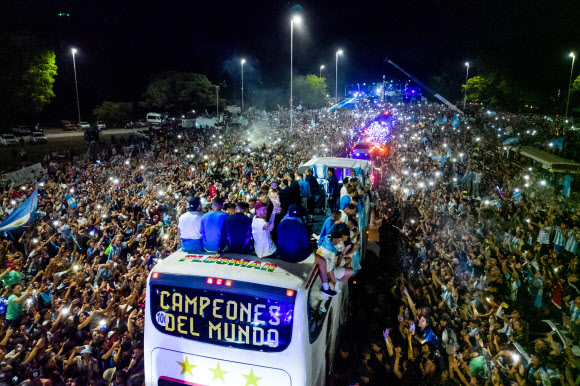 Argentina‘s players celebrate on board a bus with a sign reading “World Champions” with supporters after winning the Qatar 2022 World Cup tournament as they leave Ezeiza International Airport en route to the Argentine Football Association (AFA) training centre in Ezeiza, Buenos Aires province, Argentina on December 20, 2022. AFP 연합뉴스