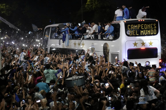 Fans welcome home the players from the Argentine soccer team that won the World Cup after they landed at Ezeiza airport in Buenos Aires, Argentina, Tuesday, Dec. 20, 2022. AP 연합뉴스