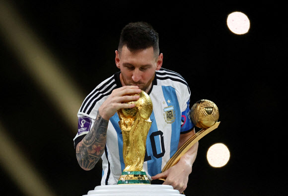 FIFA World Cup Qatar 2022 - Final - Argentina v France - Lusail Stadium, Lusail, Qatar - December 18, 2022 Argentina‘s Lionel Messi kisses the World Cup trophy after receiving the Golden Ball award as he celebrates after winning the World Cup. REUTERS 연합뉴스