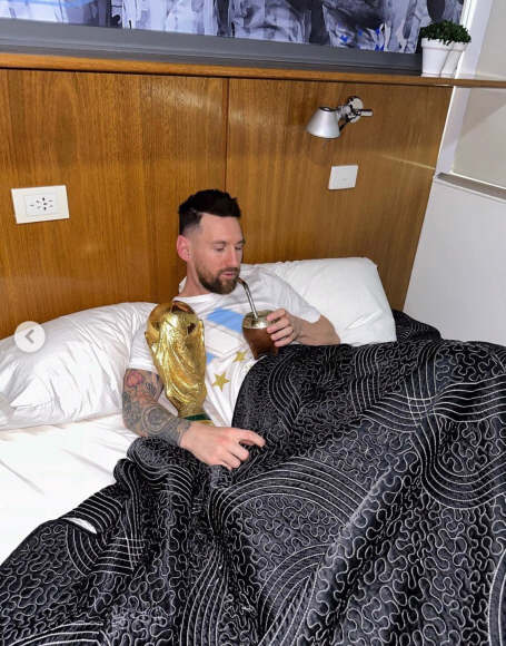 침대에서 월드컵 우승 트로피와 함께 음료 마시는 아르헨티나 축구 선수 리오넬 메시. 메시 인스타그램 캡처