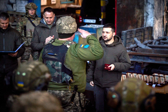 전쟁 300일이 되는 20일(현지시간) 한 손에 훈장을 쥔 볼로디미르 젤렌스키(오른쪽) 우크라이나 대통령이 격전지 바흐무트를 방문해 군인으로부터 경례를 받고 있다.  바흐무트 UPI 연합뉴스