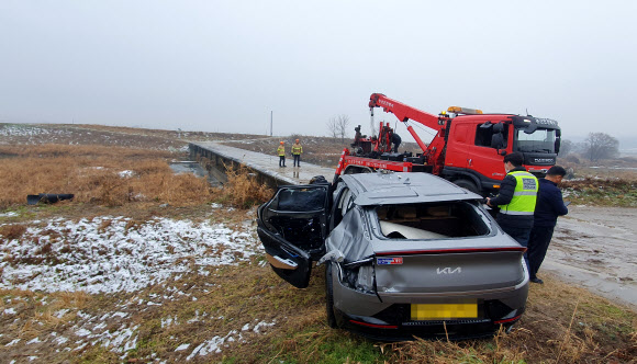 눈길에 미끄러진 택시 하천으로 추락