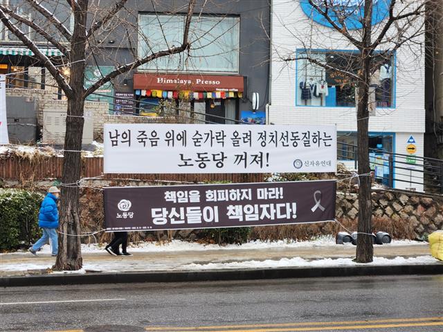 이태원 참사 시민분향소가 마련된 서울 용산구 녹사평역 인근에 이태원 참사를 추모하는 현수막과 이를 비방하는 내용의 현수막이 나란히 걸려 있는 모습.