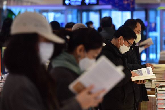 실내에서도 마스크 착용 의무를 완화하는 방안이 검토되고 있는 가운데 21일 서울 종로구 교보문고에서 마스크를 쓴 시민들이 책을 고르고 있다. 홍윤기 기자