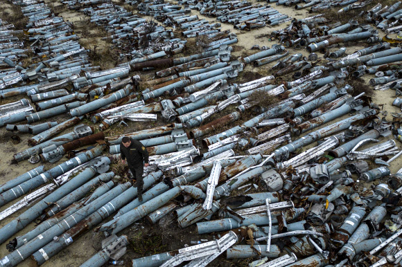 전쟁 조사관이 22일(현지시간) 우크라이나 하르키우를 공격하는데 사용된 러시아 로켓의 부품들을 관찰하고 있다. AP