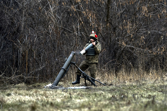 22일(현지시간) 우크라이나 전쟁의 격전지인 바흐무트에서 한 군인이 포를 쏠 준비를 하고 있다. AP