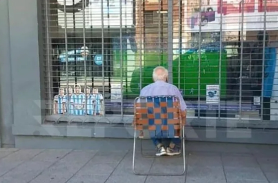 사진=할아버지가 아르헨티나의 4강전을 문 닫은 상점 앞에서 시청하고 있다. (출처=레포르테시엔)