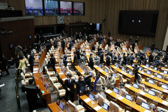 지난 24일 새벽 내년도 예산안 통과 뒤 산회가 선포되자 여야 의원들이 국회 본회의장을 나서고 있다. 연합뉴스