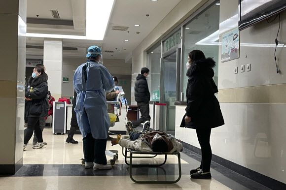 지난 22일 중국 북부 허베이성 바저우시의 한 병원에서 환자가 병상 부족으로 바닥에 누워있다.2022.12.26 AP연합뉴스