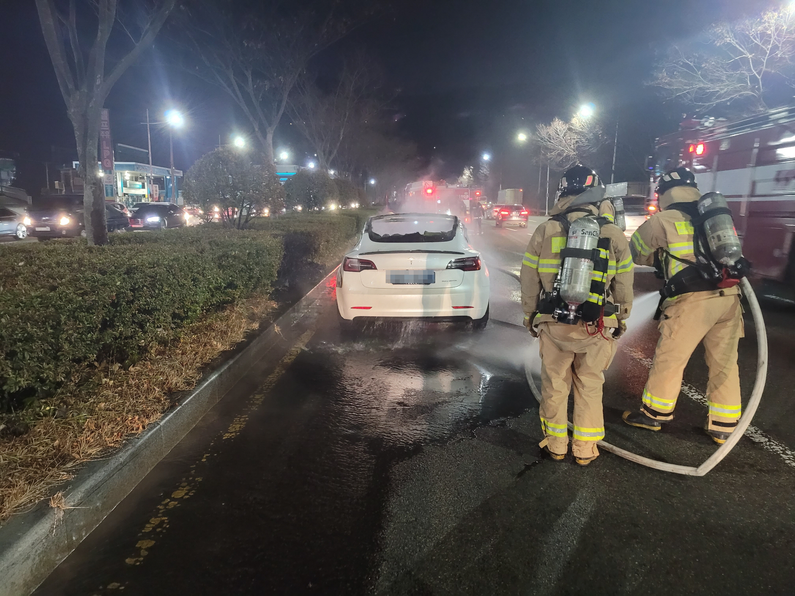 26일 부산 북구 만덕2터널 입구에서 주행 중이던 전기차에 화재가 발생해 소방관들이 진화작업을 하고 있다. 부산경찰청 제공