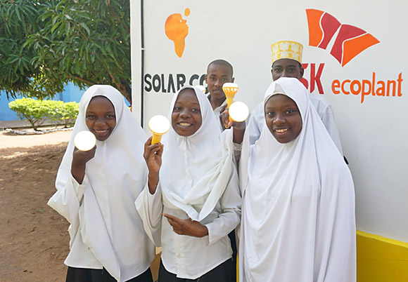 탄자니아 학생들이 충전된 솔라밀크를 들고 웃고 있다. SK에코플랜트 제공