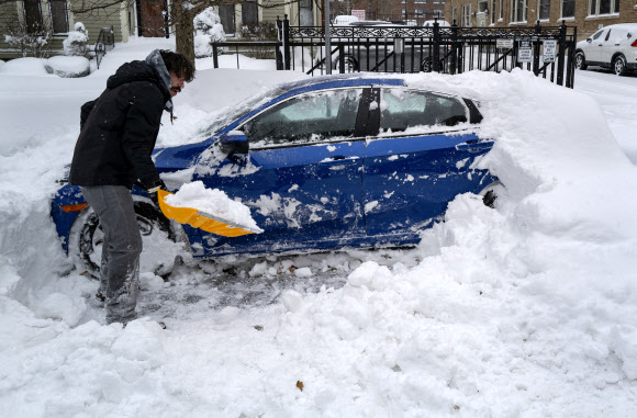 26일(현지시간) 미국 뉴욕주 버펄로에서 한 시민이 차를 움직이려 눈을 치우고 있다. AP