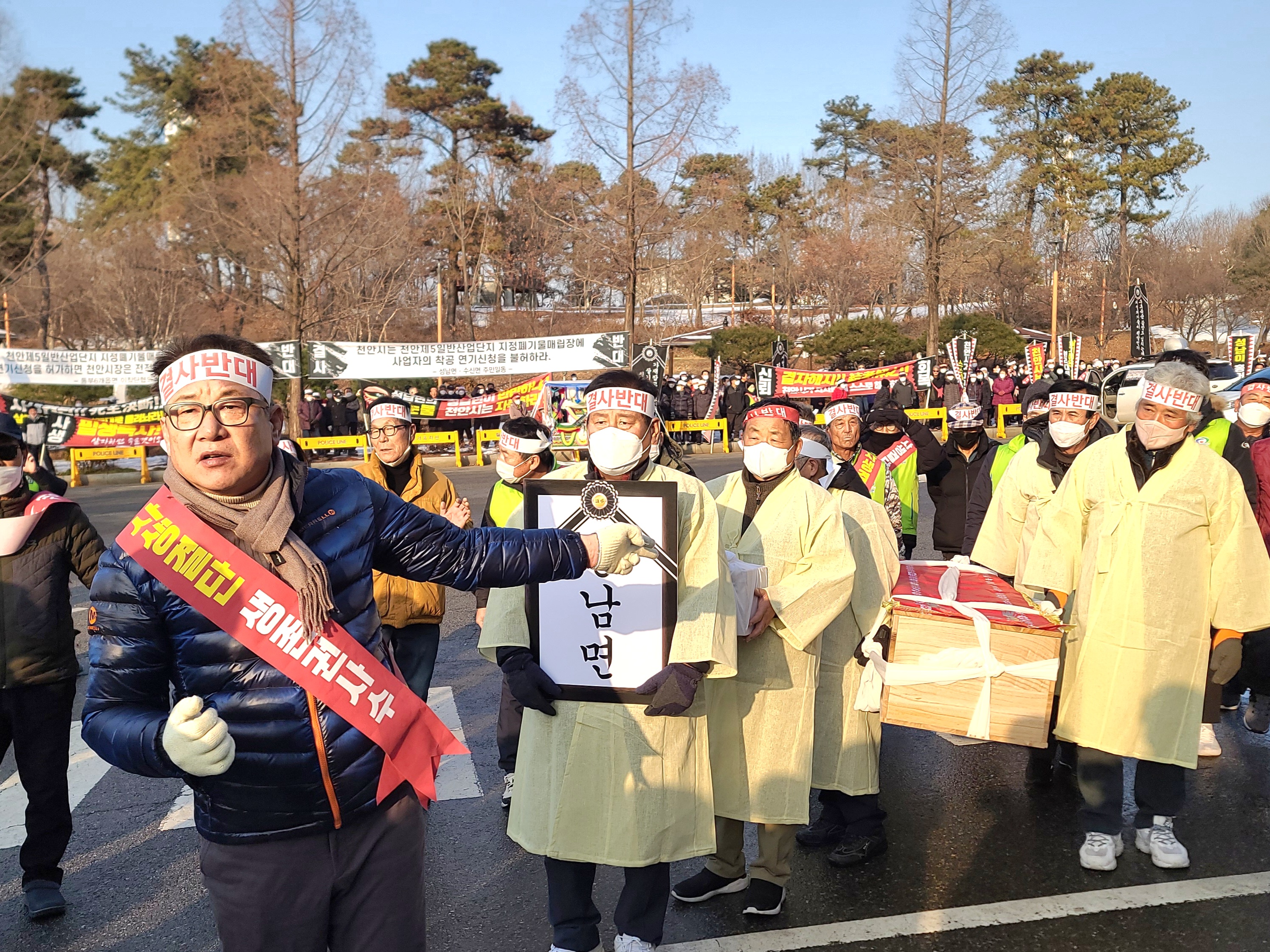 천안시 성남면 주민들이 ‘성남면’이라고 적힌 영정과 항의서가 들어있는 유골함, 관 등을 들고 상복 차림으로 천안시를 항의 방문하고 있다.