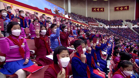 대표증 들어보이는 북한 소년단원들