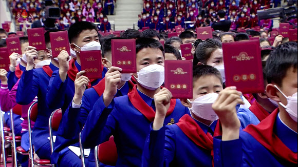 대표증 들어보이는 북한 소년단원들