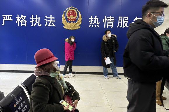 중국 베이징의 한 자치경찰대에 주민들이 여권 등 서류 신청을 위해 줄을 서 있다. 중국은 3년간 유지했던 강력한 코로나19 방역정책에서 벗어나 관광용 여권 발급을 재개할 것이라고 최근 밝혔다. 2022.12.28 AP 연합뉴스