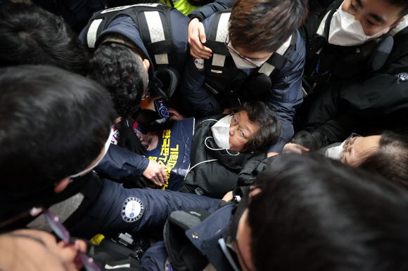 3일 지하철 4호선 동대문역사문화공원역에서 서울교통공사 관계자들이 휠체어를 탄 전국장애인차별철폐연대 활동가들의 탑승을 저지하기 위해 에워싸고 있다. 연합뉴스