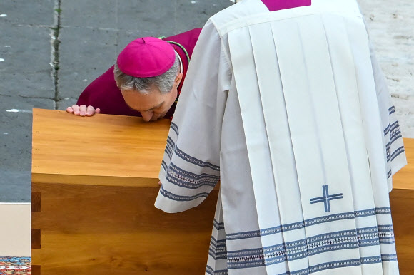 German Archbishop Georg Gaenswein kisses the coffin of Pope Emeritus Benedict XVI at the start of his funeral mass at St. Peter‘s square in the Vatican, on January 5, 2023. - Pope Francis will preside on January 5 over the funeral of his predecessor Benedict XVI at the Vatican, an unprecedented event in modern times expected to draw tens of thousands of people. AFP 연합뉴스