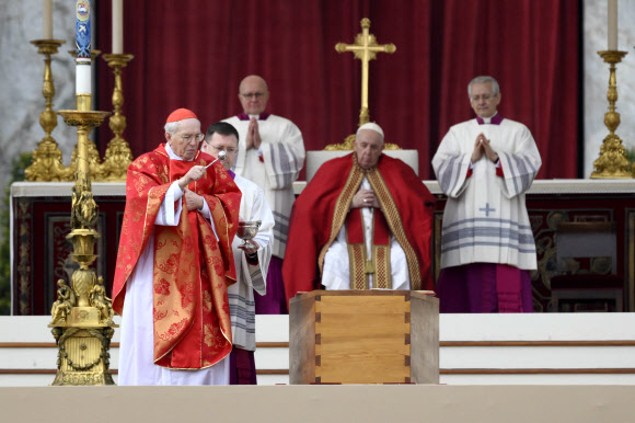 프란치스코(가운데) 교황이 5일 바티칸 성 베드로 광장에서 열린 베네딕토 16세 전 교황의 장례미사에서 조반니 바티스타 리(왼쪽) 추기경이 베네딕토 16세의 관을 축복하는 모습을 지켜보고 있다. 바티칸 EPA 연합뉴스