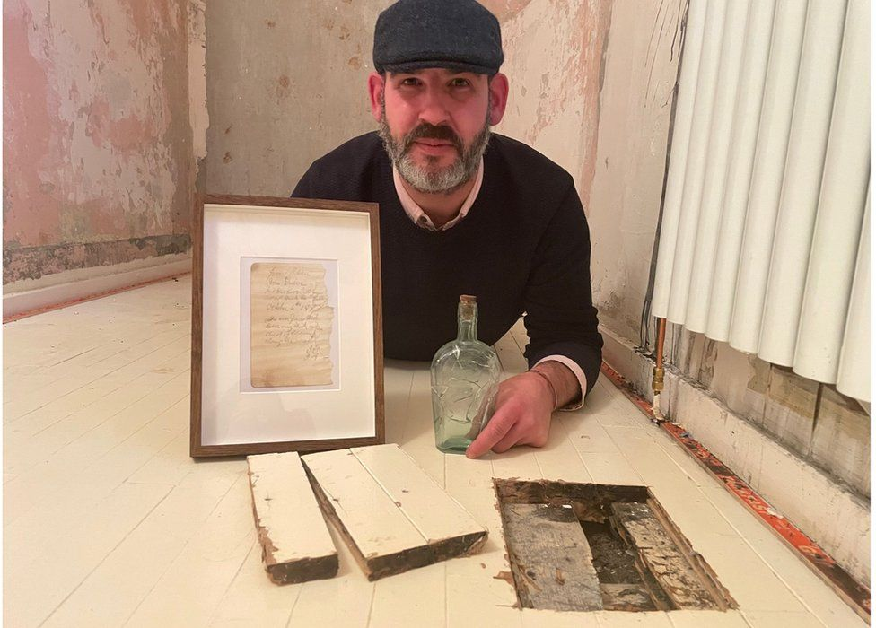 지역 역사학자 제이미 코스토피네가 뜯긴 마룻바닥, 메시지가 든 병, 메시지 액자 등을 보여주고 있다. 영국 BBC 홈페이지 인용