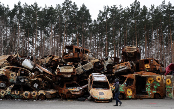 8일(현지시간) 우크라이나 키이우 외곽도시인 이르핀에 파괴된 차량들이 쌓여 있다. 차량 겉면에 누군가 그린 해바라기들이 보인다. 2023.1.10  연합뉴스