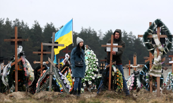 8일(현지시간) 우크라이나 키이우 외곽 도시 부차의 한 공동묘지에 민간인 희생자의 가족이 고인을 추모하고 있다. 2023.1.10  연합뉴스