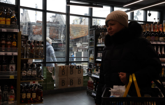 8일(현지시간) 우크라이나 이르핀의 파괴된 건물 인근 식료품점에서 시민들이 장을 보고 있다. 2023.1.10  연합뉴스