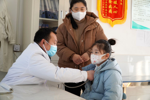 중국 산둥성의 한 진료소에서 마을 의사가 어린 환자를 진찰하고 있다. 2023.1.11 신화 연합뉴스