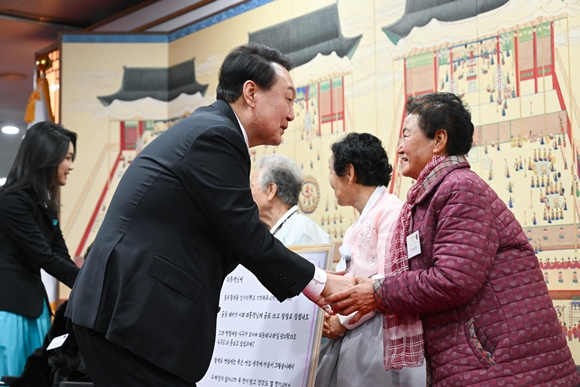 윤석열 대통령과 김건희 여사가 12일 오후 서울 용산 대통령실 청사에서 ‘칠곡할매글꼴’의 주인공인 칠곡 할머니들과 만나 인사를 나누고 있다. 2023.1.12  대통령실 제공