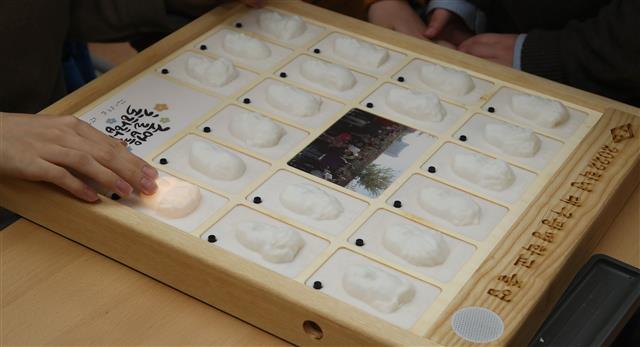 13일 오전 대구 남구 대명동 시각장애인 교육기관 대구광명학교에서 열린 2022학년도 졸업식에서 3D 프린터로 제작된 졸업앨범을 받은 졸업생들이 친구들의 얼굴을 손끝으로 만지며 목소리를 듣고 있다. 2023.1.13. 뉴스1