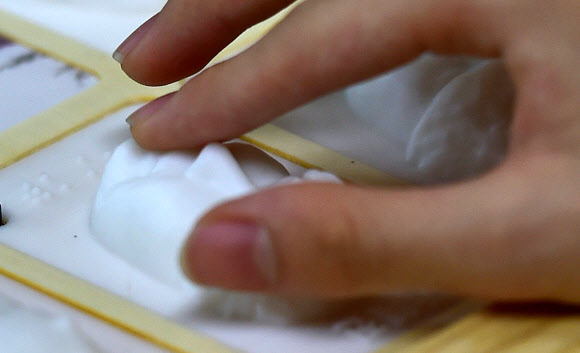 시각장애인 특수학교인 대구 남구 대구광명학교 졸업식이 열린 13일 오전 졸업생들이 3D 프린터로 만든 입체 졸업앨범 속 친구 얼굴을 손으로 만져보고 있다. 2023.01.13. 뉴시스