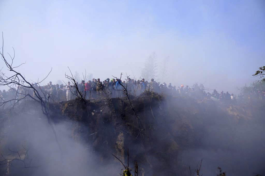 현지인들이 15일 네팔 카스키 지구 현장에서 여객기 잔해를 지켜보고 있다. 2023.01.15 AP연합뉴스