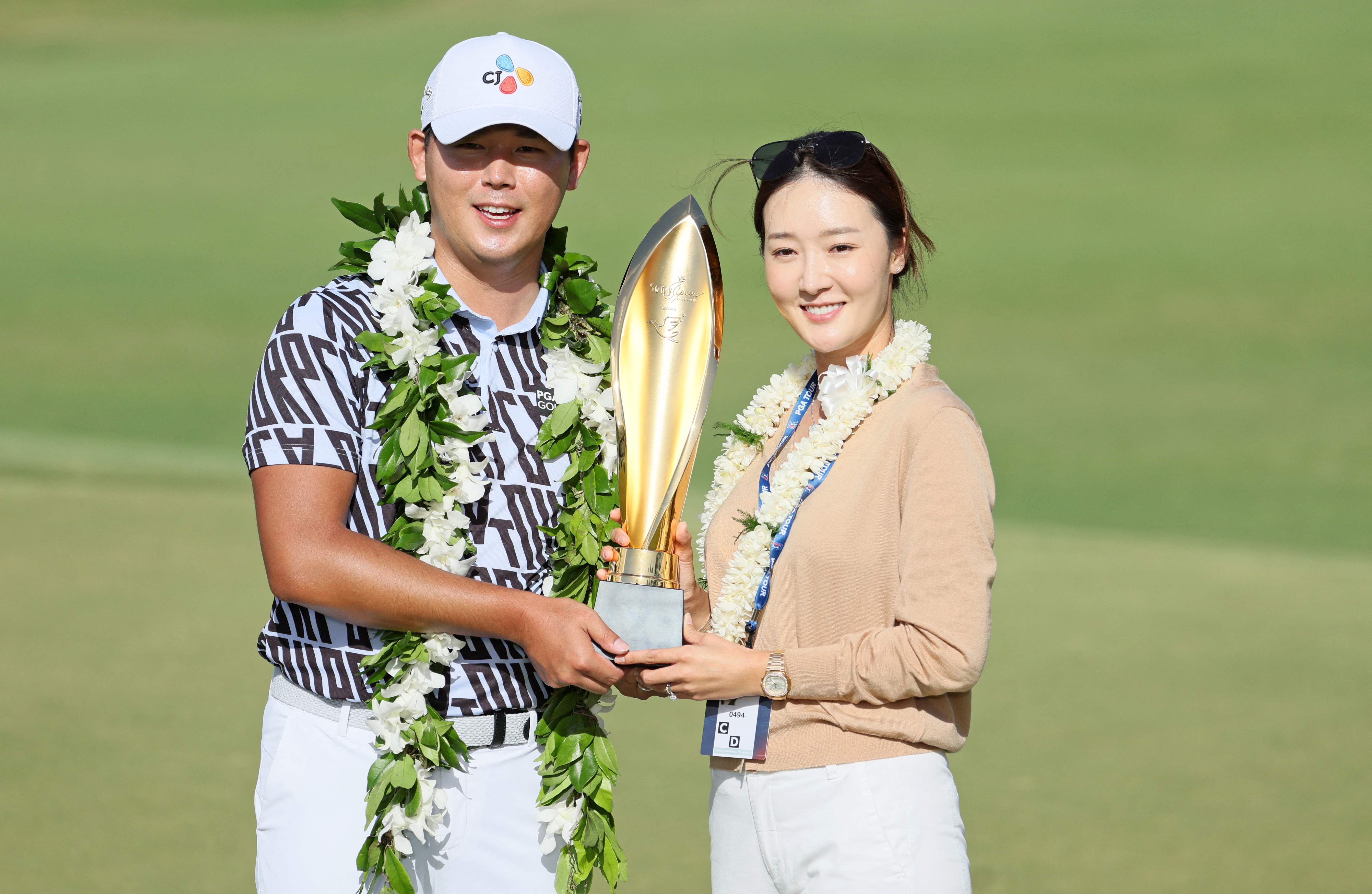 16일(한국시간) PGA 투어 소니오픈에서 우승한 김시우가 지난해 12월 백년가약을 맺은 아내 오지현과 함께 트로피를 들고 환하게 웃고 있다.  호놀룰루 AFP 연합뉴스