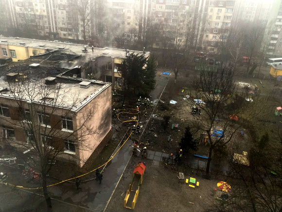 18일(현지시간) 우크라이나 키이우 외곽 브로바리에서 발생한 헬기 추락 사고 현장에서 구급대원들이 작업을 하고 있다. 2023.1.18 로이터 연합뉴스