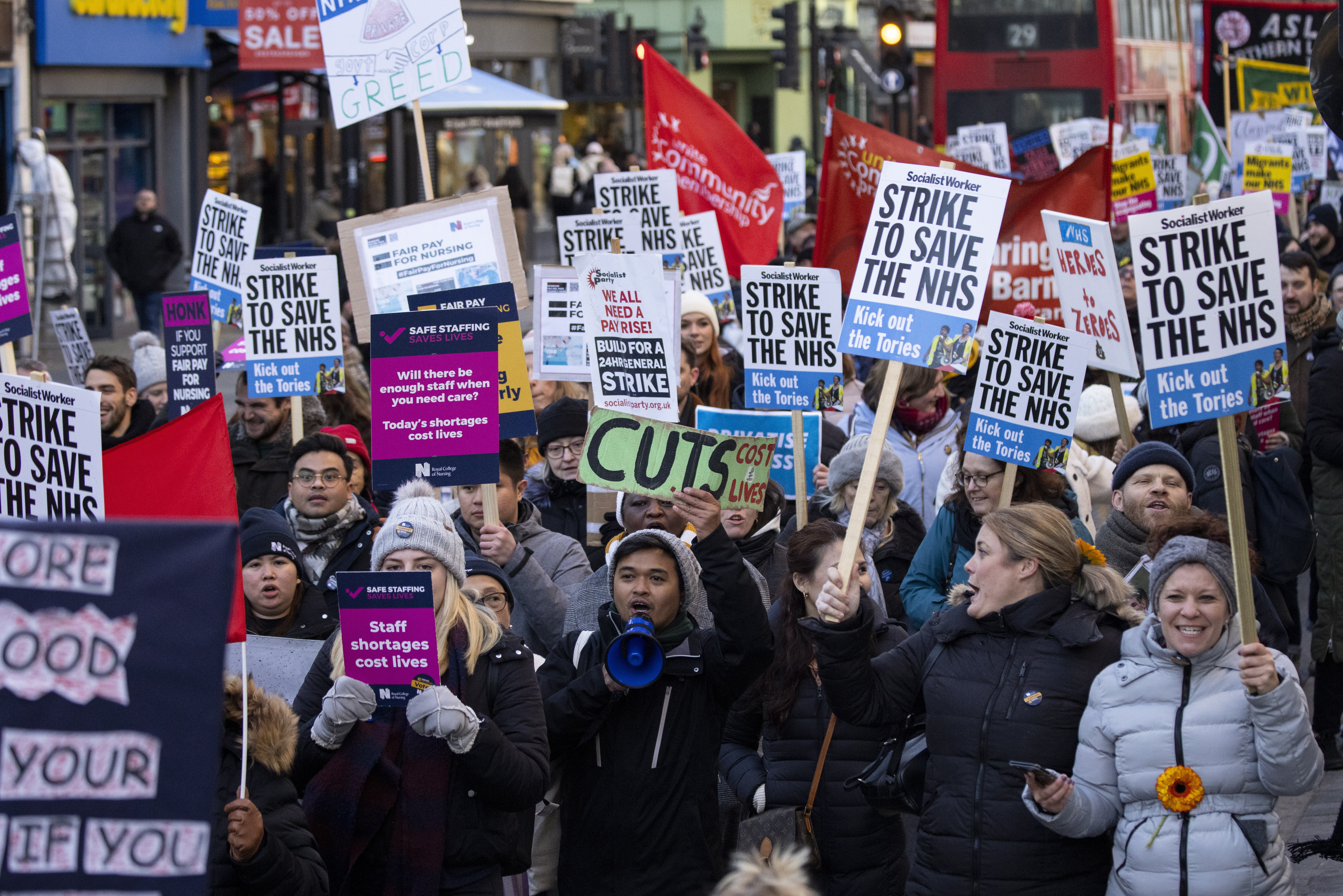 영국 국민보건서비스(NHS) 노동자들이 18일(현지시간) 런던 다우닝가에서 임금 인상과 근무조건 개선을 요구하는 팻말을 앞세워 파업 행진을 하고 있는 모습. 런던 EPA 연합뉴스