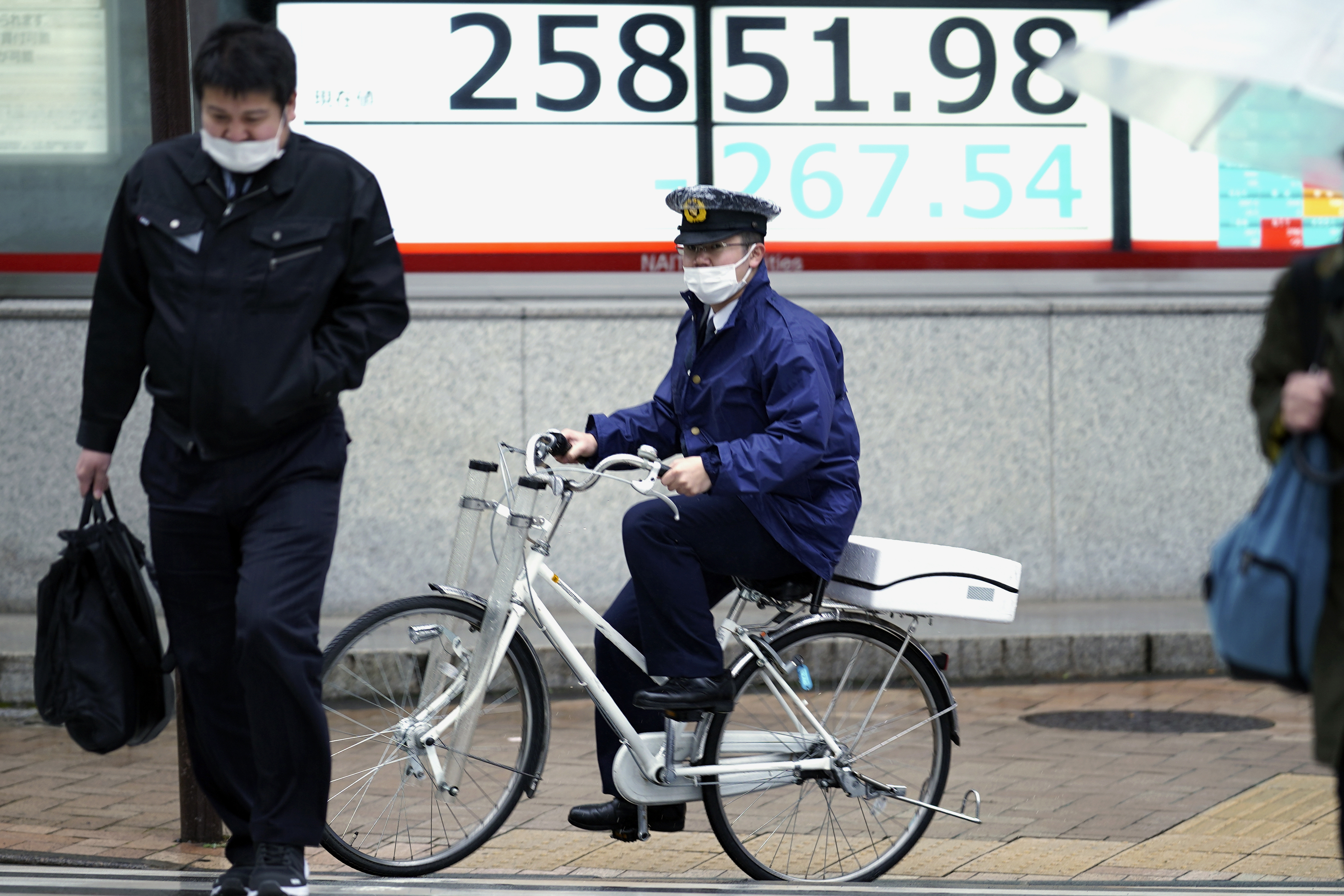 도쿄의 한 경찰관이 16일 마스크를 쓰고 자전거를 타고 있다. 도쿄 AP 연합뉴스